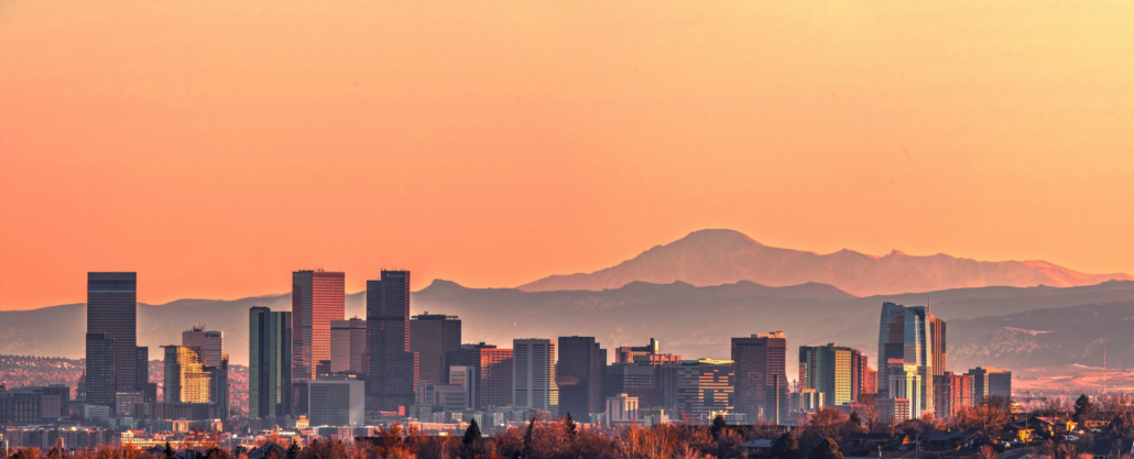 Denver Colorado skyline with the Rocky Mountains behind it