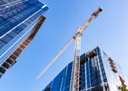 Tower crane between commercial buildings under construction.