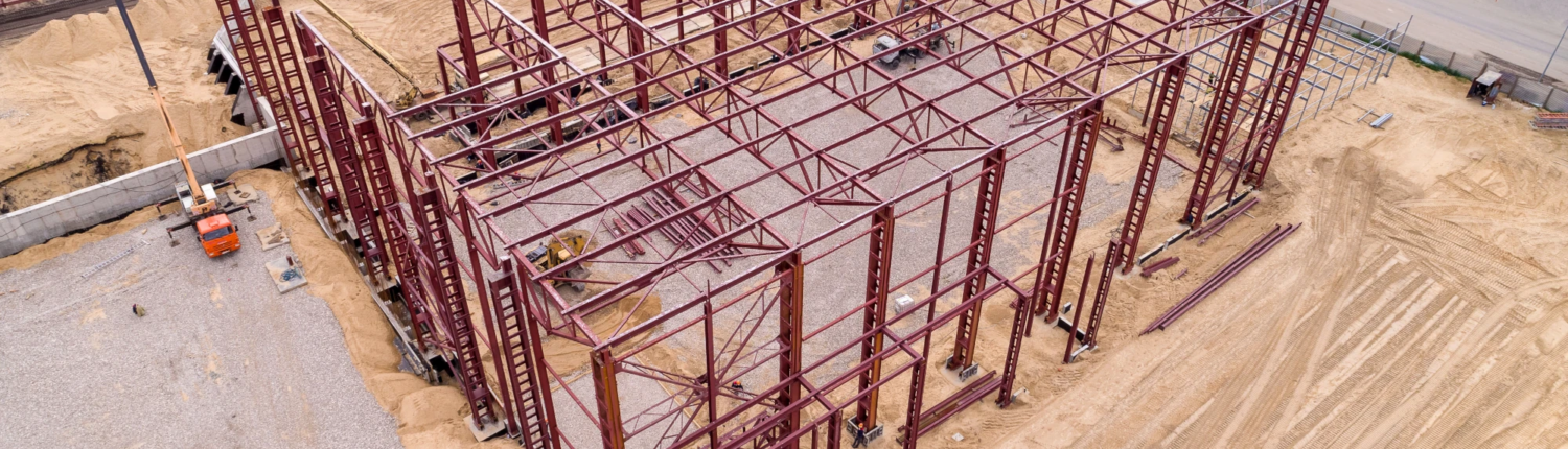 Aerial view of structural steel framework at an industrial building construction site.