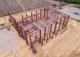Aerial view of structural steel framework at an industrial building construction site.