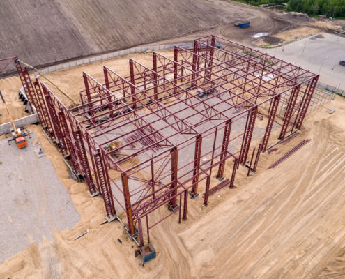 Aerial view of structural steel framework at an industrial building construction site.