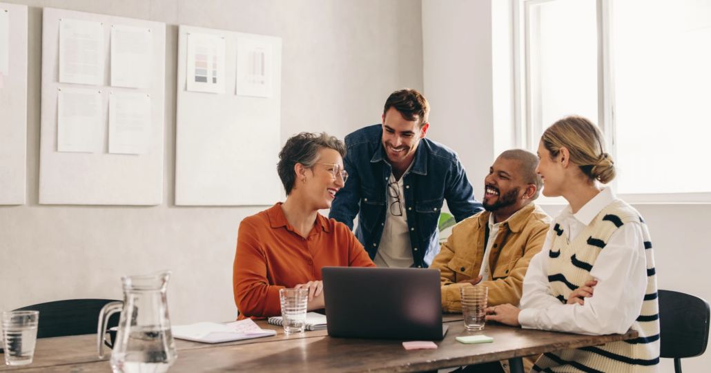 Four colleagues collaborating at a desk in an office